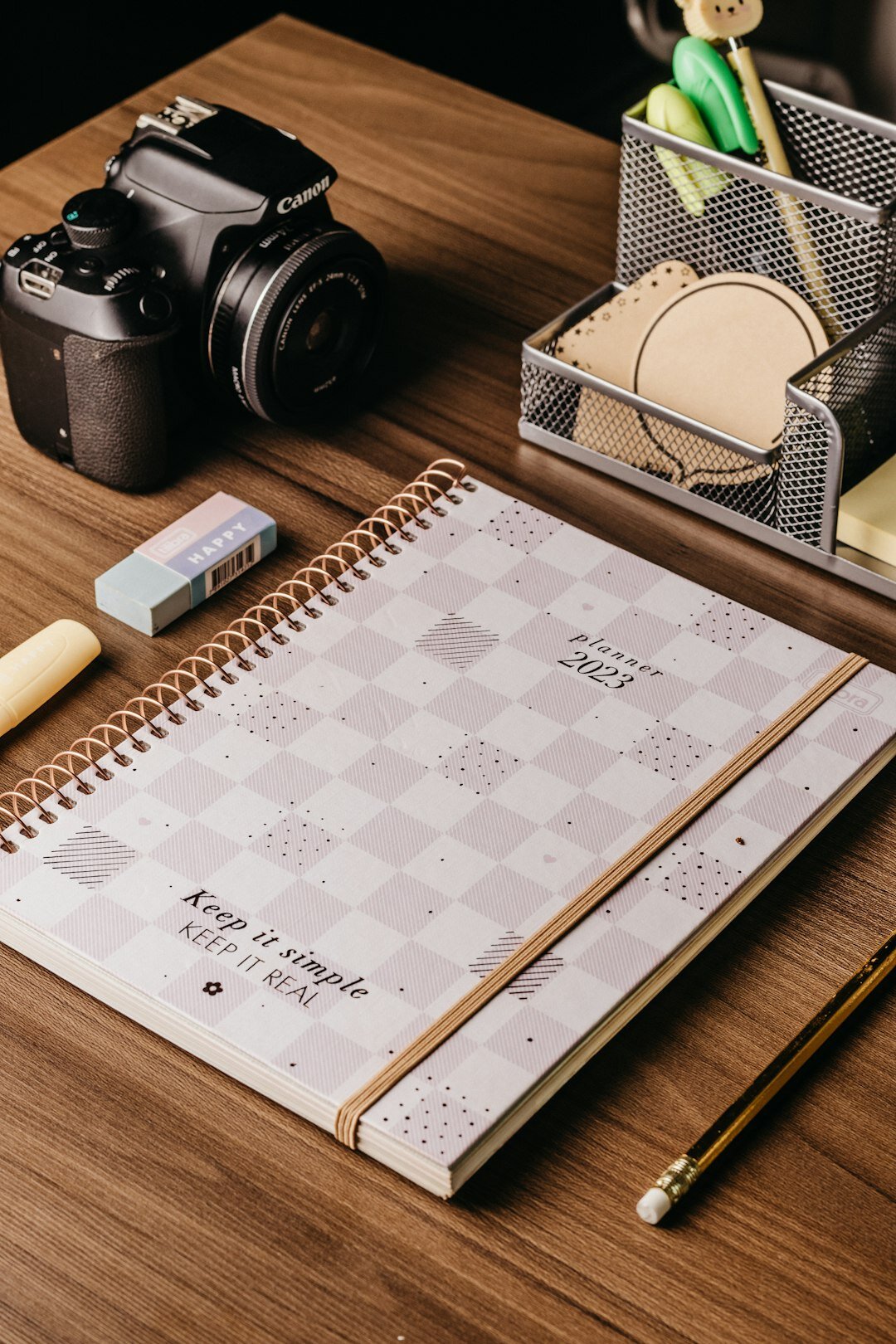 Vintage film camera and notebook resting on a wooden table